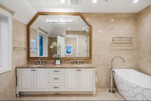 a bathroom with two sinks and a large mirror at Luxury 5-bedrooms in Vancouver Point Grey in Vancouver