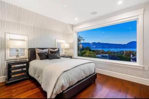 a bedroom with a bed and a large window at Luxury 5-bedrooms in Vancouver Point Grey in Vancouver