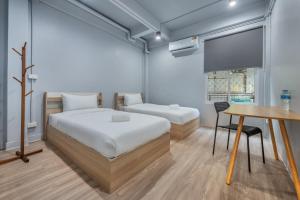 - une chambre avec un lit, une table et une télévision dans l'établissement Ti Thong Hostel, à Bangkok