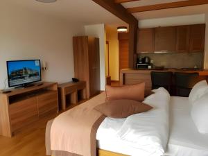 a bedroom with a white bed and a television at Vucko Apartments B229 & B230 in Jahorina