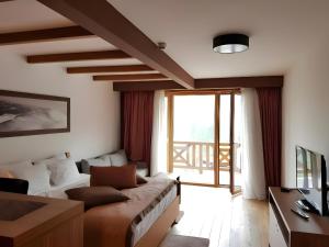 a living room with a couch and a large window at Apartments B229 & B230 in Aparthotel Vucko, Jahorina -private host in Jahorina
