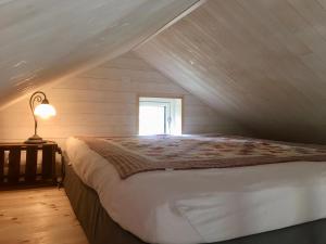 1 dormitorio con 1 cama grande en el ático en Pippis Cottage en Tingsryd
