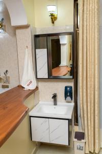 a bathroom with a sink and a mirror at Dubai infinite luxury suites in Malindi