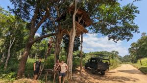 un grupo de hombres parados junto a una casa en el árbol en Yala Avian Eye Safari, en Buttala