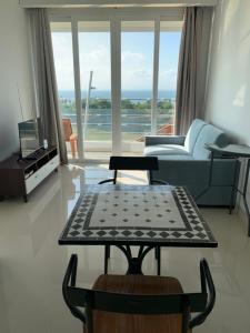 un soggiorno con divano e tavolo di Two Bedroom Apartment at The Nove Nuvasa Bay Nongsa 306 a Nongsa