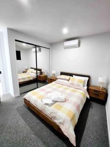 Un dormitorio con una cama grande y un espejo. en City Fringe and 2.5 bathrooms, en Melbourne