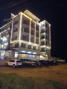 un gran edificio con coches estacionados frente a él en Khách sạn AN THỊNH 2, en Doc Let