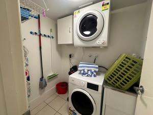 uma lavandaria com uma máquina de lavar roupa e uma máquina de lavar roupa em Kawana Waters Ocean Front Unit- Sunshine Coast em Buddina