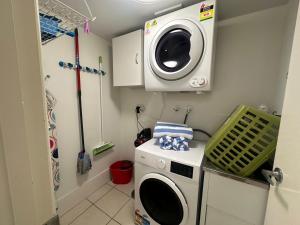 a laundry room with a washing machine and a washer at Kawana Waters Ocean Front Unit- Sunshine Coast in Buddina