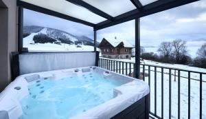 a jacuzzi tub on a balcony with a view at Sky-House Jasná Apartments in Pavčina Lehota