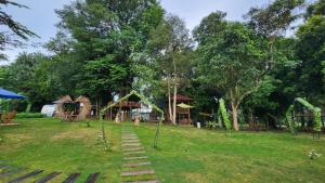 a yard with a playground and a house with trees at Two Bedroom Apartment at The Nove Nuvasa Bay Nongsa 306 in Nongsa