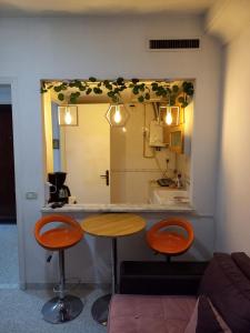 un mostrador con dos taburetes delante de un espejo en Joli studio, 17 Avenue Hedi Nouira Ennasr 2, Ariana, Tunis, en Ariana