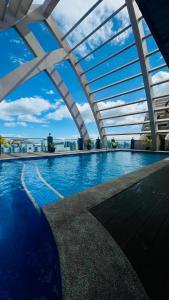an indoor swimming pool with a glass roof at 2-Bedroom Condotel Stay with Netflix, Kitchen & Washer, Near MRT Boni in Manila
