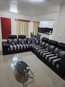 ein Wohnzimmer mit einem schwarz-weißen Sofa in der Unterkunft Bula Stay in Nadi