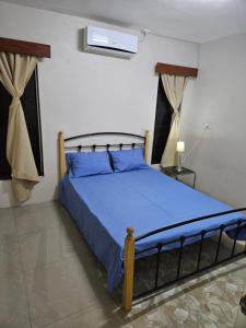 1 dormitorio con 1 cama con edredón azul en Bula Stay, en Nadi