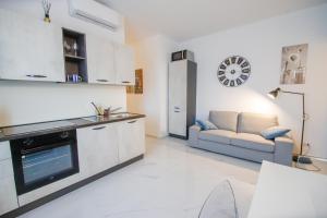 een keuken en een woonkamer met een bank en een tafel bij Moderno alloggio in zona pedonale in Chivasso