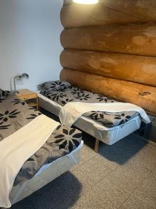 twee bedden in een kamer met een muur bij Joensuu Villa Cuisine in Joensuu