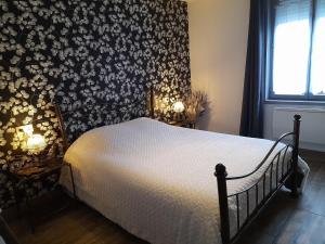 a bedroom with a bed with a floral wall at Le Gîte des 4 Saisons Maison de vacances avec parking et jardin in Saint-Omer