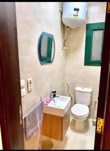 a bathroom with a sink and a toilet and a mirror at Furnished Chalet Apartment at La Hacienda Ras Sedr in Ras Sedr