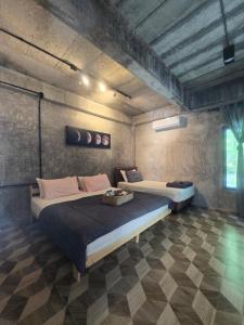 a bedroom with two beds in a room at The Box Promkiri (เดอะบ๊อค พรหมคีรี) in Ban Pak Ram