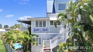 a white building with a blue sign on it at Bella Abode on Bribie - Loft with Pool in Bongaree