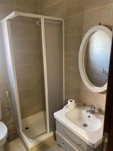 a bathroom with a shower and a sink and a mirror at Furnished Chalet Apartment at La Hacienda Ras Sedr in Ras Sedr