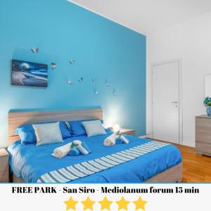 una camera da letto con un letto blu e due peluche sopra di [Free park- San Siro - Mediolanum Forum 15 min] a Milano