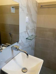 ein Bad mit einem Waschbecken und einem Spiegel in der Unterkunft Villa castle in Nuwara Eliya