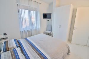 een witte slaapkamer met een bed en een raam bij Moderno alloggio in zona pedonale in Chivasso