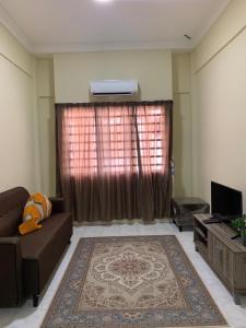 een woonkamer met een bank en een televisie bij DHW Homestay in Simpang Ampat Semanggol