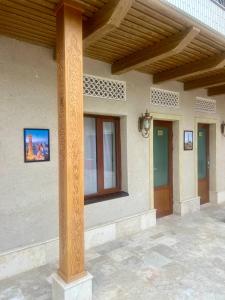 a building with a column and windows and a porch at Hotel Rizvan Buhara in Bukhara