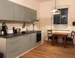 a kitchen with white cabinets and a wooden table at Alte Bäckerei Gnade auf Rügen in Sehlen