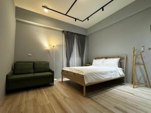 um quarto com uma cama e uma cadeira em 澄靛民宿 em Taitung City