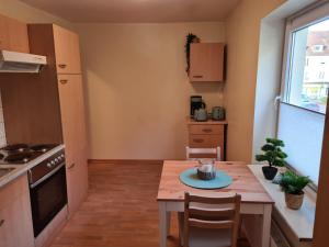 a small kitchen with a wooden table and a small table and chairs at Ferienwohnung Camping Buchholz in Hamburg