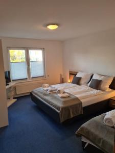 a bedroom with a large bed and two windows at Ferienwohnung Camping Buchholz in Hamburg