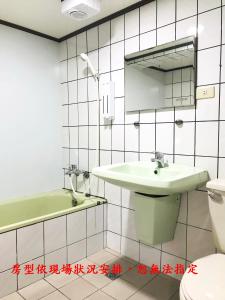 een badkamer met een wastafel, een toilet en een bad bij Gui Zu Hotel in Luodong