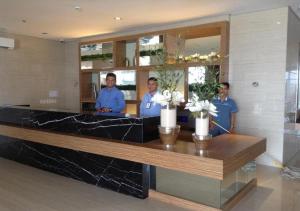 three men standing behind a counter in a lobby at Blowing In The Wind in Tagaytay