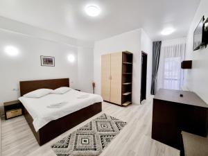 Un pat sau paturi într-o cameră la Hotel Perla Oltului