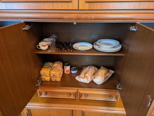 a cabinet with plates and croissants and bread at naturnah am Donauradweg in Riedlingen