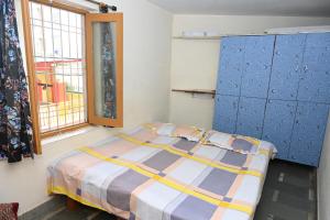 um quarto com uma cama, uma janela e armários azuis em Siddhivinayak Temple Guest House em Varanasi