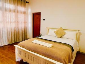 ein großes Bett in einem Zimmer mit Fenster in der Unterkunft Villa castle in Nuwara Eliya