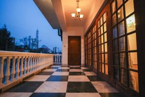 a balcony with a checkerboard floor and a door at Anand Homestay in Srinagar