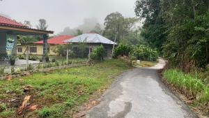 a dirt road next to a house and a yard at Chalet Naqib in Gerik