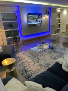 a living room with a couch and a tv on a wall at JD HOME in Beauvais