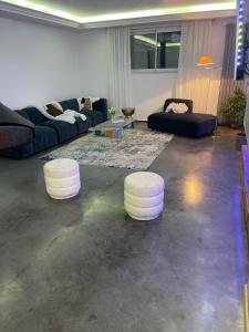 博韋的住宿－JD HOME，带沙发和2张白色凳子的客厅