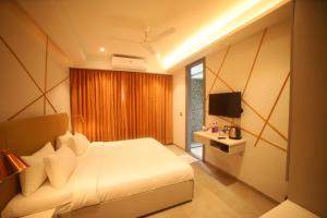 a hotel room with a bed and a television at Waltair Abode in Visakhapatnam
