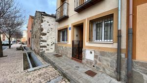 un bâtiment avec une porte sur le côté d'une rue dans l'établissement El Pajar del Toro, à San Cristóbal de Segovia