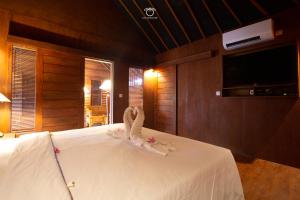 ein Schlafzimmer mit einem weißen Bett und einem Handtuch darauf in der Unterkunft The Kori Sire in Tanjung