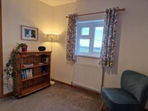 a living room with a chair and a window at Ty Beca in Clynderwen