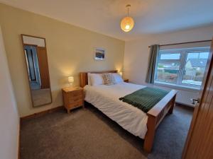 a bedroom with a bed and a window at Ty Beca in Clynderwen